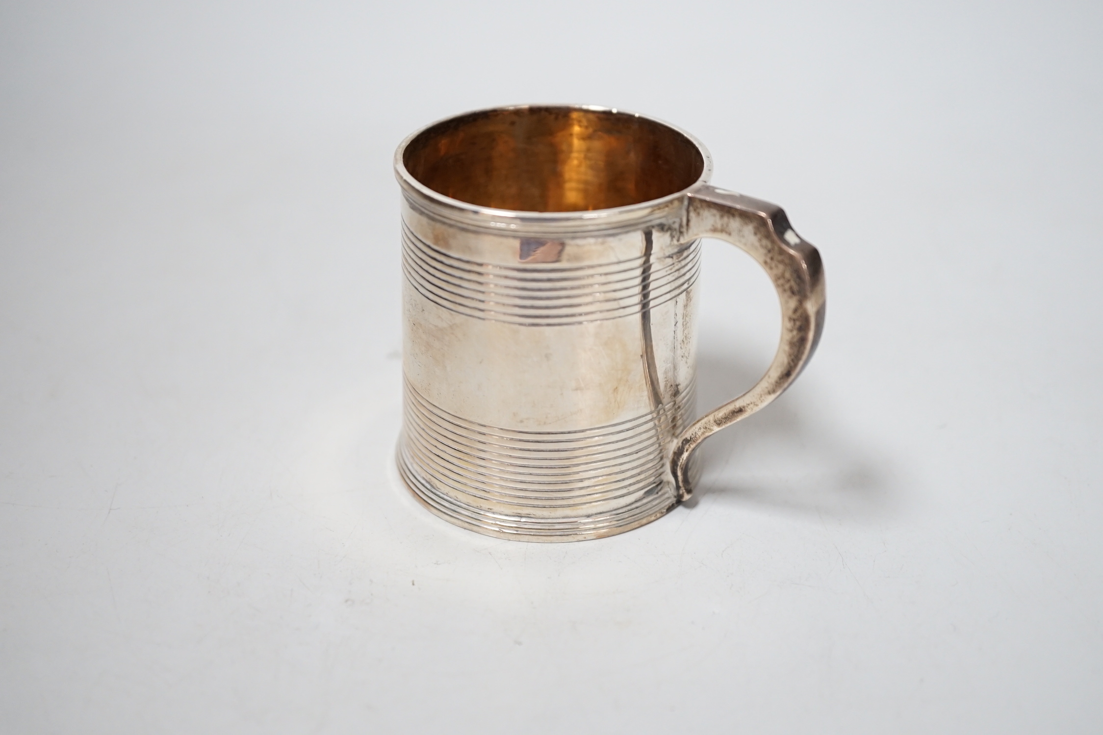 A cased George III reeded silver christening mug, William Bennett, London, 1811, height 6cm.